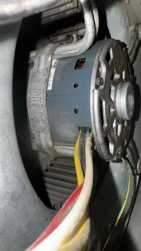 Responded to emergency call for non-operational furnace. Inspection revealed significant rust and corrosion on internal components, particularly on the metal panel housing. Replaced damaged blower motor assembly, reconnected electrical wiring (red, yellow, white, green), and restored system functionality.