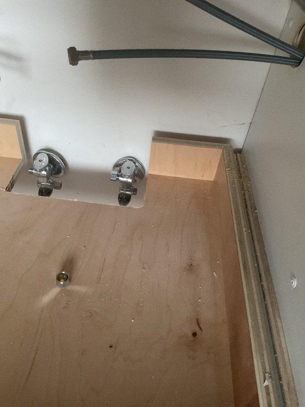 Installed drain assembly for customer's sink, including proper P-trap configuration to prevent sewer gas backflow. Also inspected shower/bath valve fixtures and drain opening in wooden subfloor, which appear to be part of an ongoing bathroom installation project.