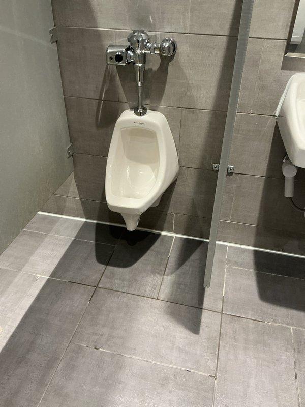 Responded to service call regarding urinal flooding after multiple flushes. Upon inspection of the commercial restroom, identified drainage issue in wall-mounted urinal with chrome flush valve. Cleared blockage in drain line to restore proper drainage function and prevent future flooding incidents.