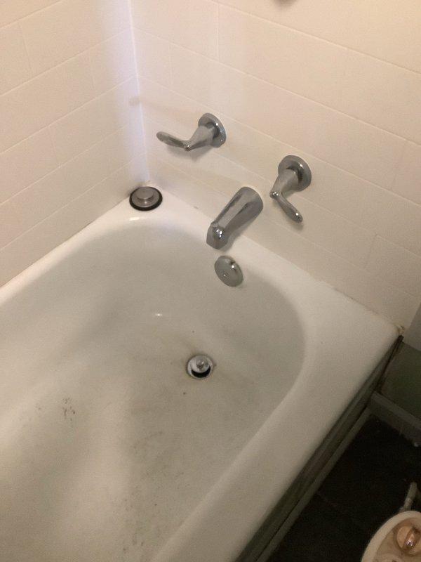 Completed waste and overflow replacement on basement shower. Opened wall behind shower to access plumbing. Removed old rusted drain assembly and installed new PVC waste line with proper connections to existing plumbing system. Verified proper drainage function after installation.