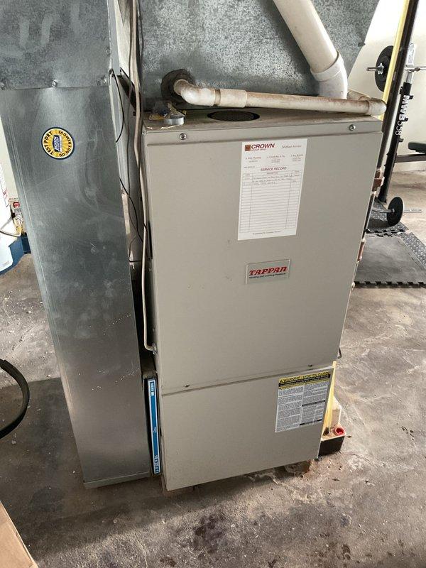 Responded to service call for Tappan furnace with heating failure and diagnostic code of two red flashes. Inspected blower motor assembly and identified faulty draft inducer motor with visible corrosion at base. Replaced draft inducer motor assembly, reconnected wiring harness, and verified proper venting through PVC exhaust. System now operating normally with no error codes.