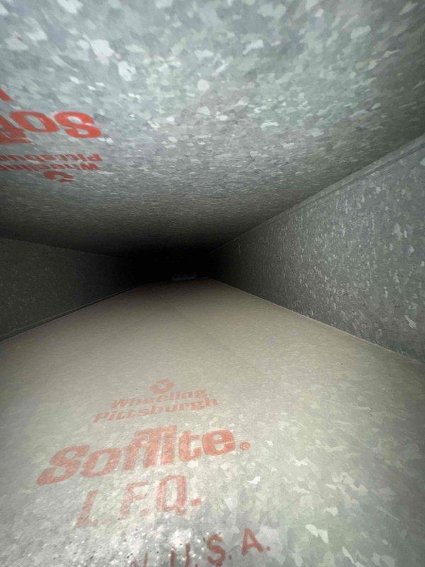 Performed comprehensive duct cleaning service on a 14-vent system. Inspection revealed significant rust accumulation in the air handler drain pan area, indicating potential moisture issues. Thoroughly cleaned all ductwork including main supply lines marked with "Spirolite L.F.Q." manufacturer stamps, which were in satisfactory condition with no structural damage observed.