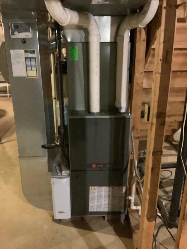Completed installation of a Trane furnace system with PVC intake/exhaust venting in basement utility area, including conversion from natural gas to propane. Also installed a 90-gallon power-vent hot water tank with propane configuration. All connections properly secured and system tested for proper operation.