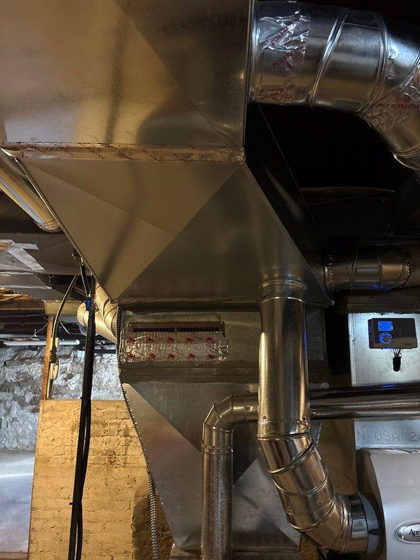 Completed installation of new ductwork system with custom metal fabrication for improved airflow efficiency. Installed floor register in wooden flooring with proper sealing and connection to main trunk line. System was tested and confirmed operational with digital control panel properly calibrated.