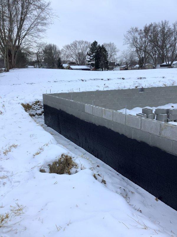 Conducted site assessment for electrical service requirements at property with new modular home installation. Evaluated power supply needs from main service to home and additional requirements for septic system. Foundation work observed in progress with concrete block walls partially completed; will need to coordinate electrical installation with ongoing construction.