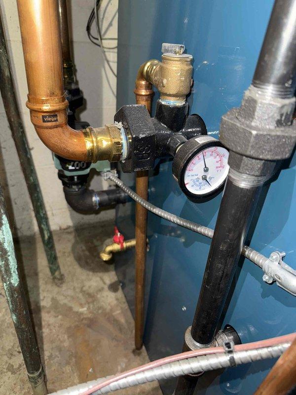 Performed scheduled maintenance on boiler system and identified deteriorated sealant where exhaust pipe enters chimney. Inspected pressure regulator valve and water system components, confirming proper operation with all readings within normal parameters. Recommended repair of deteriorated chimney connection to prevent potential exhaust leakage.