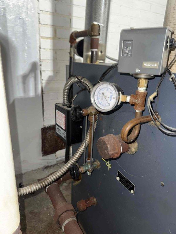 Performed routine MVP Heating maintenance service on existing boiler system. Inspected pressure gauge readings and Honeywell control components which were operating within normal parameters. Noted deteriorating pipe insulation around wall penetration that should be monitored for potential future replacement.