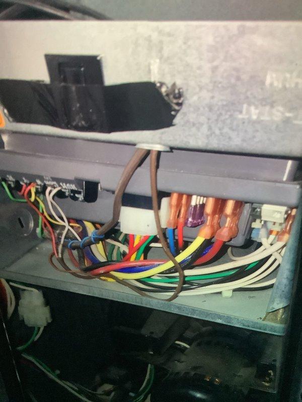 Performed comprehensive IAQ inspection on 20-25 year old air quality equipment. Examined electrical connections and wiring integrity at control panel, noting multiple colored wires connecting to terminals. Inspected heat exchanger assembly with particular attention to the fin condition and burner components. System remains operational but showing age-related wear.