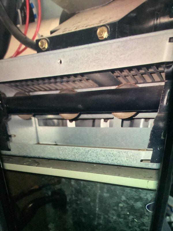 Performed comprehensive IAQ inspection on 20-25 year old air quality equipment. Examined electrical connections and wiring integrity at control panel, noting multiple colored wires connecting to terminals. Inspected heat exchanger assembly with particular attention to the fin condition and burner components. System remains operational but showing age-related wear.