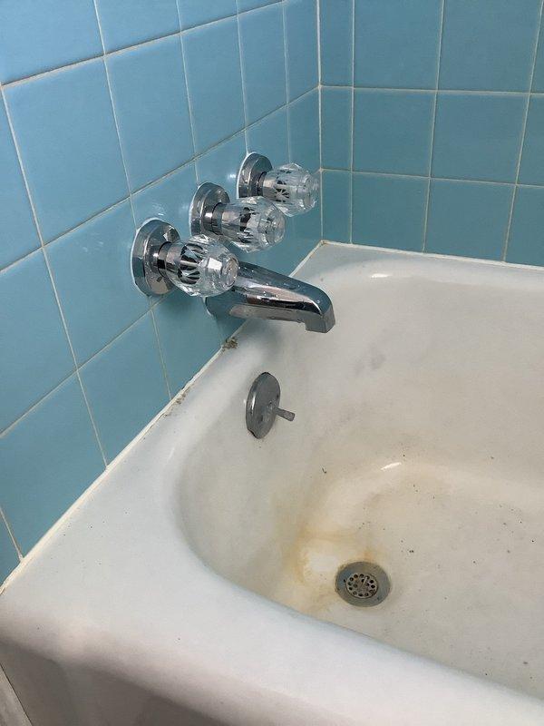 Installed new Moen 3-handle shower valve in bathroom with existing light blue ceramic tile. Added ball valves and transition fitting for riser to complete the installation. Parts were ordered for will call pickup to replace the aging fixture that showed significant wear and discoloration.