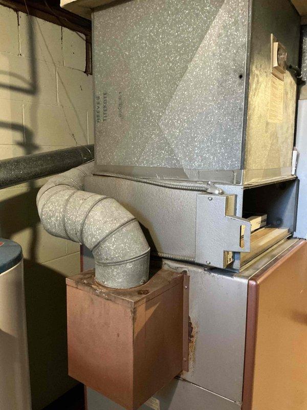 Performed inspection of existing heating system that appears to be severely outdated per customer. Current unit shows significant wear with damaged housing, exposed internal components, and insulation protruding through the upper section. Recommended full system replacement due to age-related deterioration and potential safety concerns with the current installation.