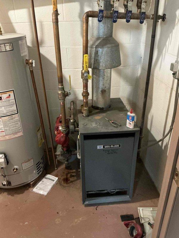 Conducted inspection of Weil-McLain boiler system in basement utility room. System appears aged but operational with proper expansion tank and valve configuration. Client has maintained heat functionality for 20+ years. Provided estimate for potential replacement or servicing as requested.
