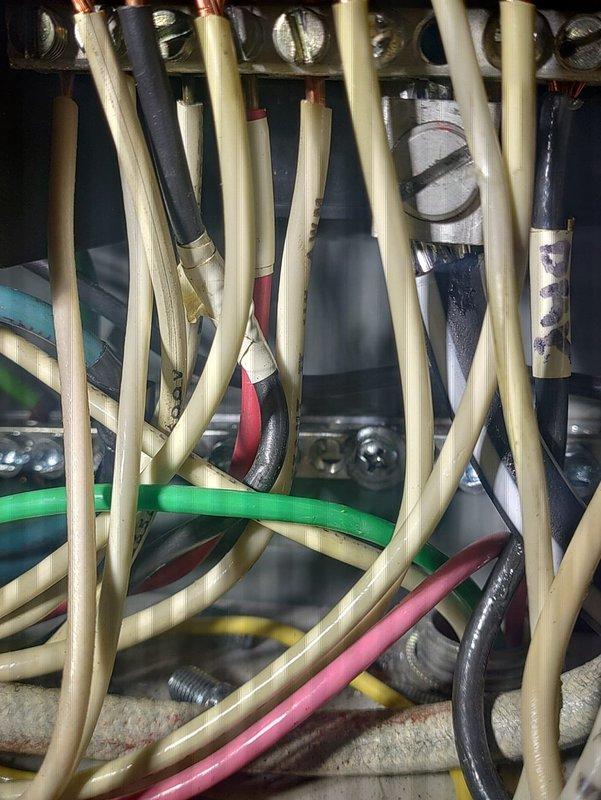 Met with inspector to review electrical panel wiring and plumbing installation. Documented electrical junction box showing multiple wire types (beige, green, pink, black, and red) in metal housing. Also photographed copper pipe assembly with valve configuration, meter gauge, and brass fittings for inspection documentation.