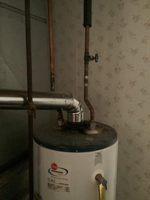 Responded to customer's call regarding leaking hot water tank. Upon inspection, found Guardian Fury gas water heater showing signs of corrosion and mineral deposits around pipe connections. Replaced aging unit with new Rheem Fury gas water heater, ensuring proper installation of all copper pipes and connections with appropriate valving.