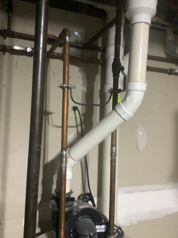 Inspected client's home for reported water heater corrosion and upstairs leak. Examined bathroom shower stall with metal-framed door and flexible shower hose. Evaluated basement plumbing infrastructure, including copper pipes, PVC connections, and pump component, to identify source of leak and assess corrosion damage on hot water tank.