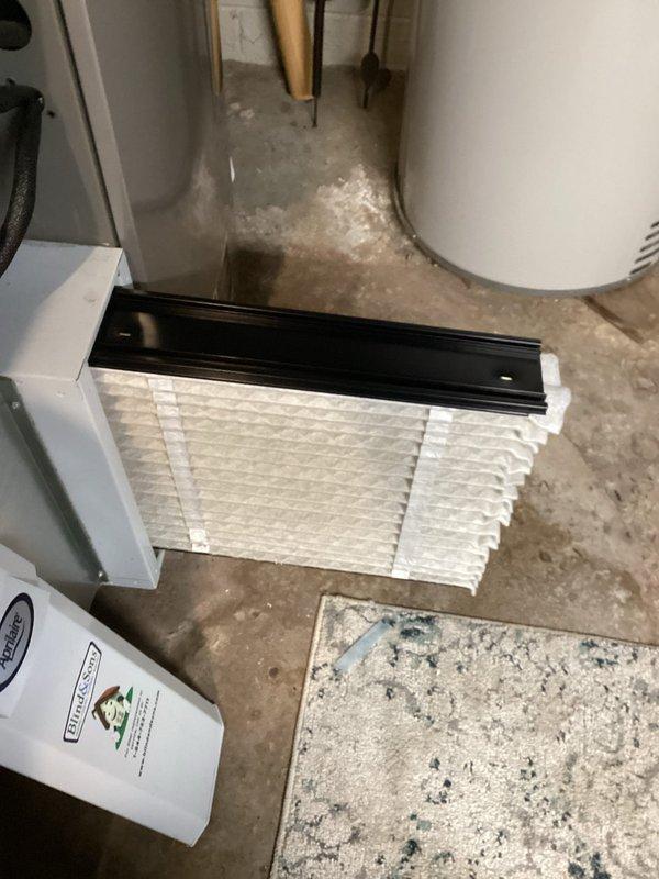 Performed routine MVP heating maintenance service including filter replacement on residential furnace system. Inspected complete HVAC setup including main furnace unit, PVC ventilation pipes, and auxiliary wall-mounted component. System appears properly installed with all connections intact and functioning normally.
