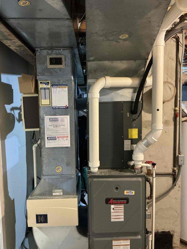 Performed evaluation of 20-year-old Bryant/Carrier furnace system in basement utility area. Documented existing installation including ductwork configuration, ventilation piping, and electrical connections. Proposed replacement of aging system with new high-efficiency unit. Current installation shows standard PVC venting and proper mechanical room setup with adequate clearances for replacement.