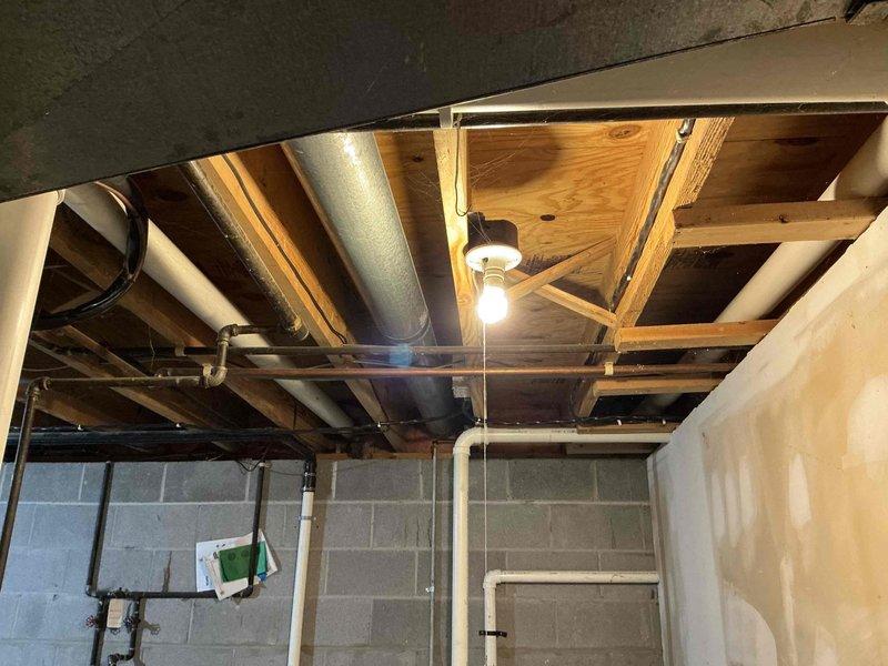 Performed evaluation of 20-year-old Bryant/Carrier furnace system in basement utility area. Documented existing installation including ductwork configuration, ventilation piping, and electrical connections. Proposed replacement of aging system with new high-efficiency unit. Current installation shows standard PVC venting and proper mechanical room setup with adequate clearances for replacement.