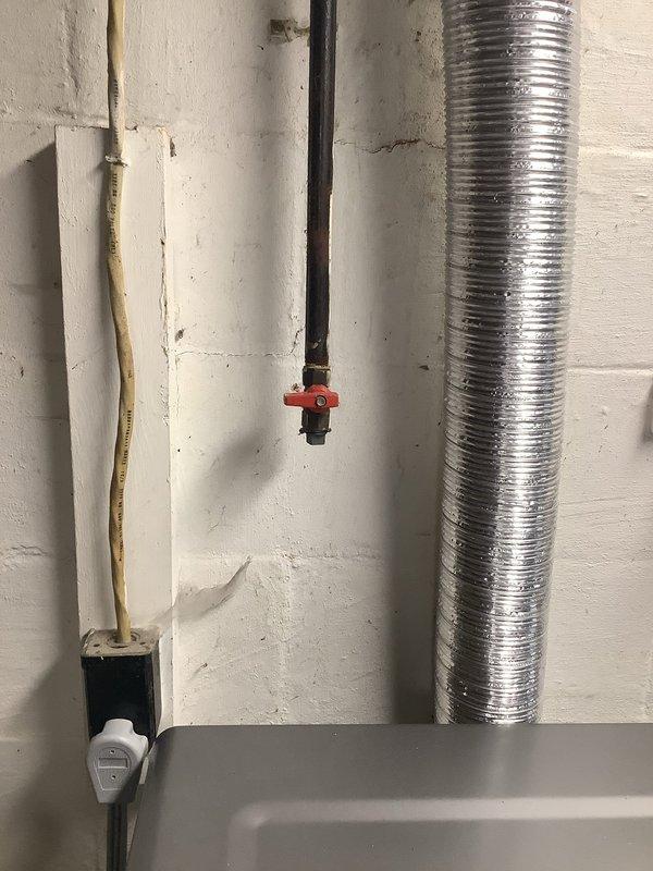 Installed new gas piping for natural gas washer and dryer connection as per estimate. Connected black iron pipe with appropriate shut-off valve featuring red handle. Performed pressure testing with gauge showing approximately 95-100 PSI to verify system integrity and ensure no leaks in the installation.