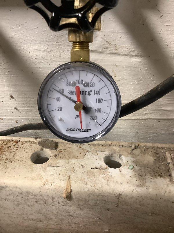 Installed new gas piping for natural gas washer and dryer connection as per estimate. Connected black iron pipe with appropriate shut-off valve featuring red handle. Performed pressure testing with gauge showing approximately 95-100 PSI to verify system integrity and ensure no leaks in the installation.