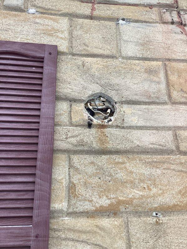 Responded to service call regarding loose exterior electrical wiring with sagging concerns. Upon inspection, found deteriorated wall-mounted light fixture with significant corrosion at connection points and a compromised electrical access point in the masonry wall with exposed wiring. Secured wiring, repaired mounting hardware, and sealed exposed access point to restore safety compliance ahead of approaching storm conditions.