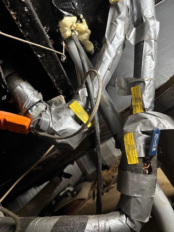 Replaced deteriorated heat tape on exterior waterline pipes underneath mobile home to prevent freezing. Installed new heat tape with proper insulation and secured with metallic wrapping to ensure cold weather protection. Verified all connections and confirmed proper installation of protective elements on the plumbing system.