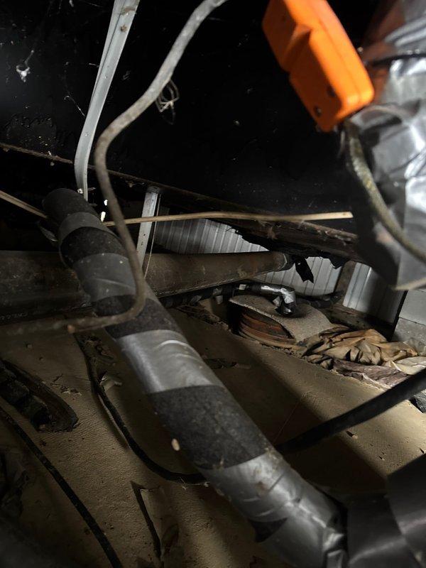 Replaced deteriorated heat tape on exterior waterline pipes underneath mobile home to prevent freezing. Installed new heat tape with proper insulation and secured with metallic wrapping to ensure cold weather protection. Verified all connections and confirmed proper installation of protective elements on the plumbing system.