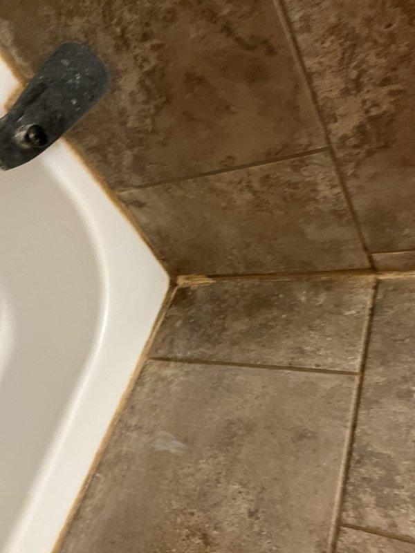 Investigated water leak from main floor bathroom into basement in 1942 home. Visual inspection revealed moisture staining at bathroom fixture base with discoloration where floor tiles meet the porcelain. Further examination of the basement ceiling/joists showed water damage along pipe pathways with visible PVC and copper plumbing lines. Repaired leaking pipe connection and sealed fixture base to prevent future water intrusion.
