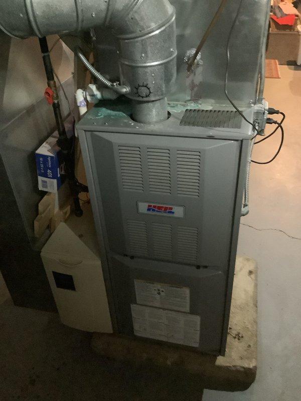 Successfully installed a new 80% efficient furnace in a residential basement setting. Unit was properly mounted on a concrete pad with all necessary ductwork connections completed. Installation included connecting the humidifier and ensuring all electrical components were properly wired according to manufacturer specifications.
