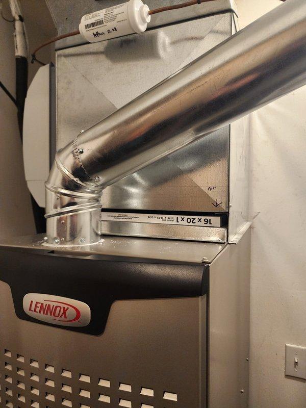 Completed installation of a new Lennox HVAC system with 80% efficiency furnace and air conditioning unit. System includes properly sized and sealed 16x20 ductwork with appropriate connections and airflow direction indicators. Installed condensate trap and filter housing with the complete system now operational.