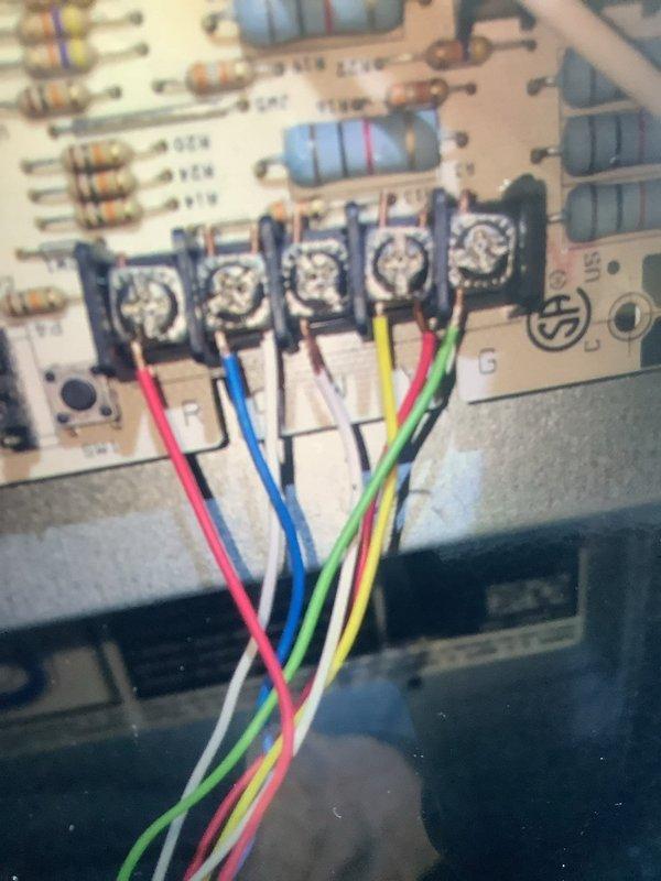Responded to service call regarding temperature discrepancy between thermostat and customer's phone app. Inspected furnace unit and found corrosion on metal surface beneath blower motor. Examined control module and circuit board connections, verifying proper termination of all wiring (red, blue, white, green, and yellow) at control board terminals. Calibrated thermostat to resolve temperature reading inconsistency.