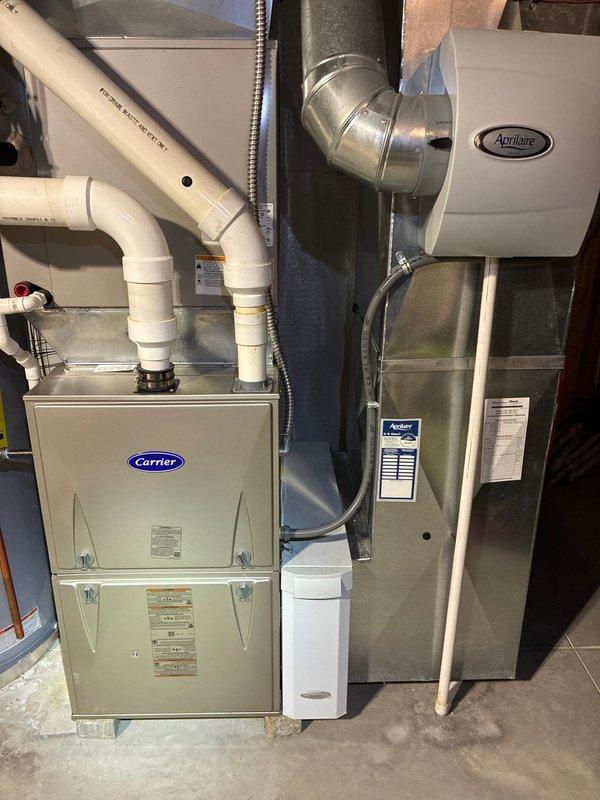 Performed routine maintenance on 4-year-old Carrier heating system with Aprilaire humidifier. Inspected burner flames and verified proper ignition sequence, checked control wiring connections, and confirmed gas valve operation. System functioning normally with all components in good working condition.