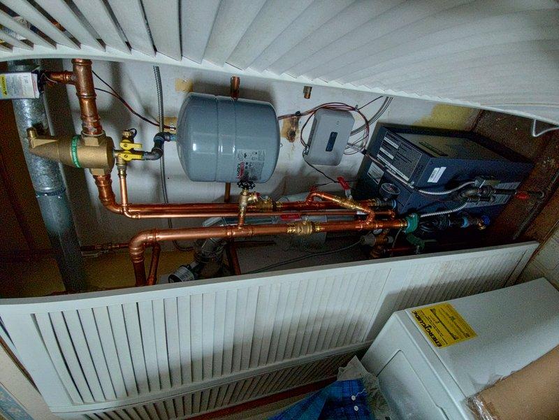 Successfully repaired copper pipe that had burst by replacing the damaged section and installing new pipe between wooden joists. System was pressure tested after repair to confirm integrity of the new installation and proper function of the heating system's expansion tank and control valves.