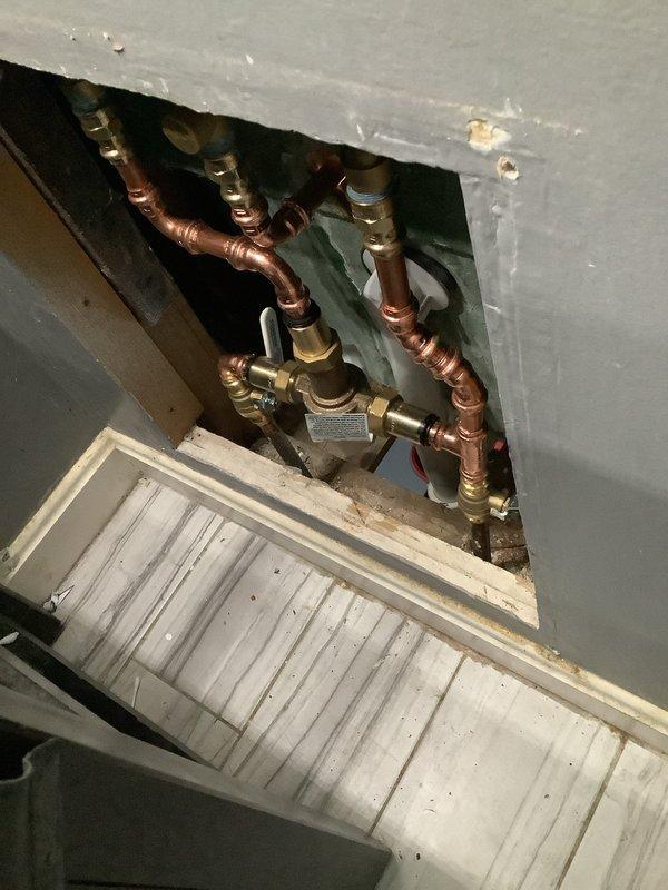 Installed new Moen 3-handle shower valve with mixing valve and ball valves after confirming parts delivery. Additionally installed customer-supplied toilet. Accessed plumbing through wall panel to complete proper connections to existing copper pipe system.