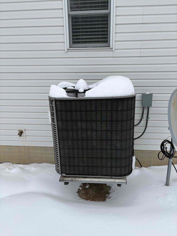 Conducted inspection of 20-year-old HVAC system experiencing intermittent heating issues. Assessment included evaluation of snow-covered outdoor AC condenser unit and basement-located furnace system with connected ductwork. Provided replacement estimate for complete system upgrade to resolve reliability concerns due to equipment age and performance problems.