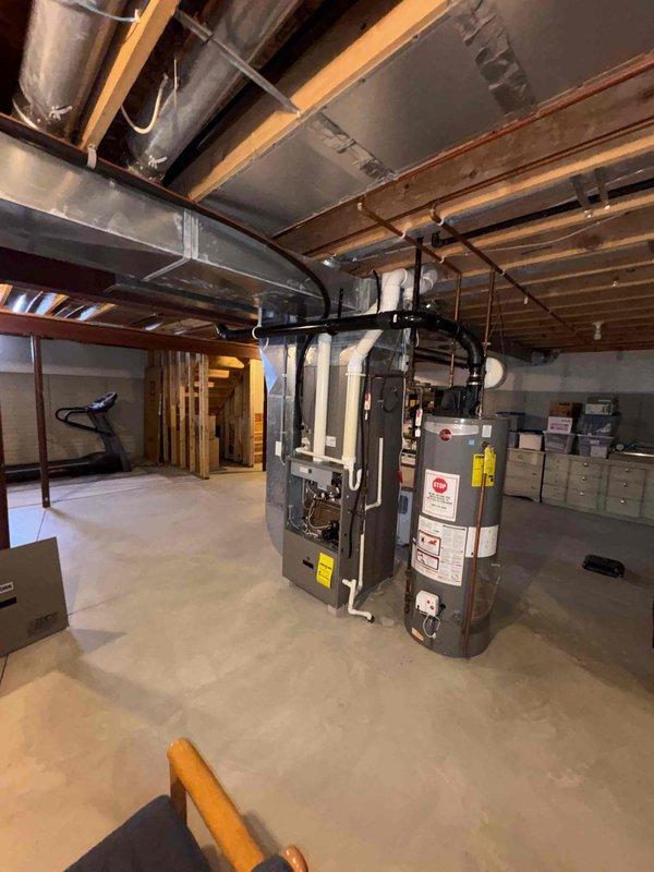 Conducted inspection of 20-year-old HVAC system experiencing intermittent heating issues. Assessment included evaluation of snow-covered outdoor AC condenser unit and basement-located furnace system with connected ductwork. Provided replacement estimate for complete system upgrade to resolve reliability concerns due to equipment age and performance problems.