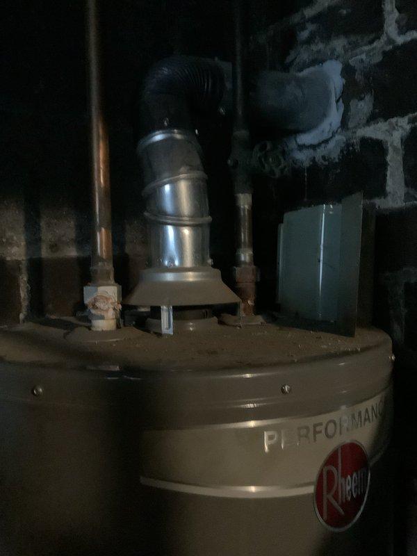 Performed diagnostic assessment on 6+ year old gas water heater with no hot water output. Inspected significant sediment buildup after customer-performed draining. Examined copper supply lines and ventilation system, noting corrosion on pipes and proper connection of metal ductwork to Rheem Performance unit. Provided replacement quote and information on financing options as requested.