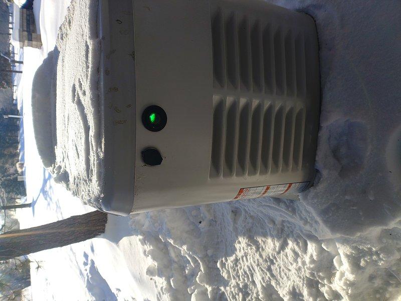 Performed generator maintenance service as per maintenance agreement. Inspected outdoor unit operating in snow conditions with proper power indication (green light operational). Examined battery connections and verified starting power battery installation with secure terminal connections. No issues found with installation despite initial concerns.