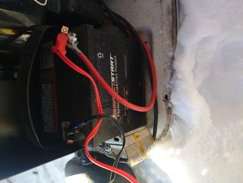 Performed generator maintenance service as per maintenance agreement. Inspected outdoor unit operating in snow conditions with proper power indication (green light operational). Examined battery connections and verified starting power battery installation with secure terminal connections. No issues found with installation despite initial concerns.