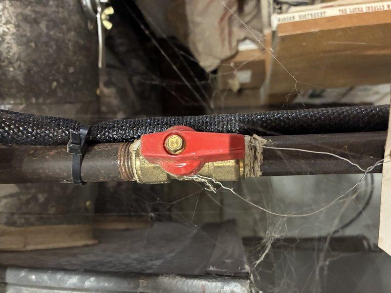 Performed annual maintenance on 5-year-old Lennox furnace. Inspected gas valve operation and confirmed proper positioning (open). Noted cobwebs around valve assembly and plumbing components. System appears to be functioning normally with all connections secure.