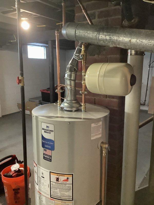 Replaced 40-gallon tall water heater with a new 40-gallon short model Bradford White unit, creating necessary clearance for installation of thermal expansion tank on cold water line. Replumbed gas line using 1/2" pipe from the existing 1/2" x 3/8" 90° fitting above ductwork to the tank and installed new 1/2" shut-off valve. Complete installation includes new ball valve and 6-year tank warranty.