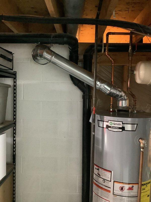 Responded to customer concern regarding improper venting on A.O. Smith ProLine commercial grade water heater. Inspected existing installation which included copper piping, expansion tank, and metal ductwork. Verified and corrected ventilation system to ensure proper exhaust routing through metal vent pipe that extends from heater top and angles appropriately across ceiling joists, bringing installation into compliance with safety standards.