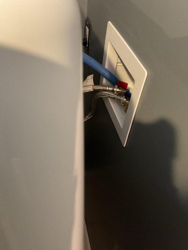Responded to service call for suspected frozen pipes causing water leakage from wall containing washer supply lines in a 75-year-old residential property. Inspection revealed no frozen pipes, but rather loose connections at the washing machine hookup box where hot and cold braided stainless steel supply lines connect. Repaired and secured connections, eliminating the leak.
