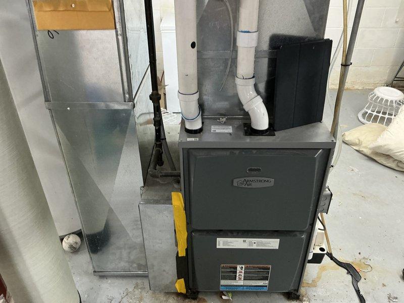 Performed HVAC system replacement including installation of an Armstrong Air furnace with proper PVC ventilation system in the utility room. Mounted unit securely with yellow brackets against concrete block wall and connected to existing ductwork. Completed electrical connections and ensured proper integration with household systems.