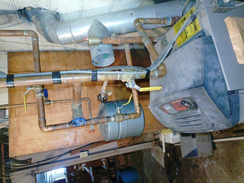 Performed diagnostic assessment on customer's oil furnace of undetermined age after receiving referral. Inspected plumbing connections and copper piping system in utility area, noting proper insulation on pipes and functionality of blue valve components. Examined expansion tank and verified integrity of ductwork connections to ensure optimal system operation.