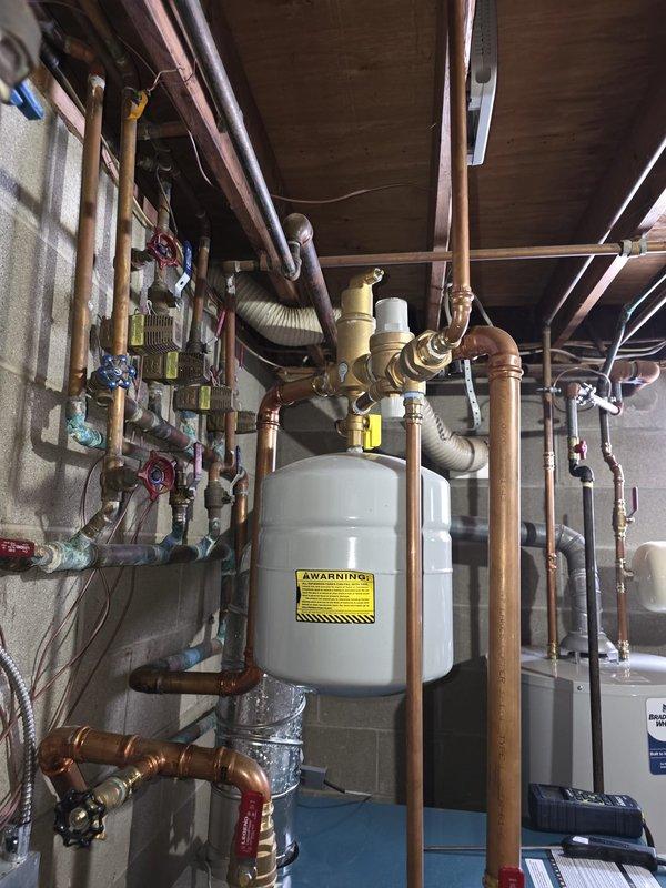 Completed routine maintenance on a 2-year-old heating system. Inspected expansion tank connections and copper piping network in utility area. Examined relay/control module wiring and connections, confirming all components are functioning properly.