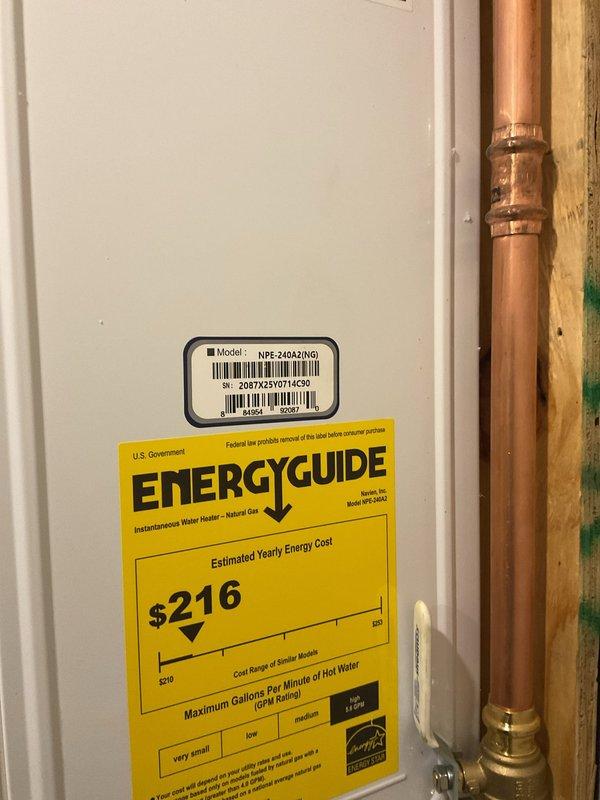 Successfully installed a Navien NPE-240A2N(G) tankless water heater with all necessary components. Complete installation included proper mounting on wooden backing board, connection of copper supply lines with brass fittings, and installation of PVC venting system. Unit is operational with Energy Star certification.