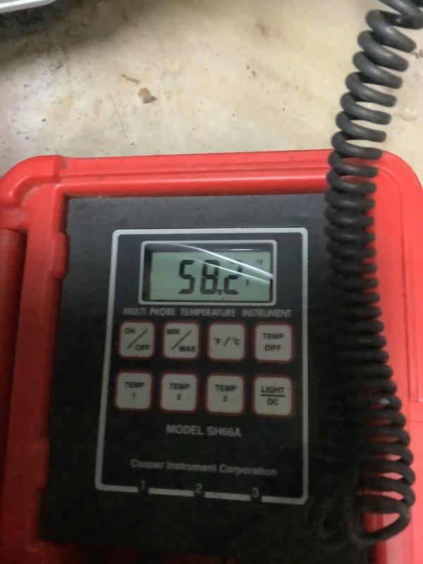 Completed installation of an 80% efficiency furnace and 40-gallon water heater in basement utility area. System includes properly mounted PVC drainage piping, secured metal conduits, and copper line connections. Post-installation temperature verification confirmed system operating at 58.2°F using Cooper SM98A multi-probe instrument.