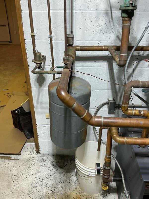 Inspected boiler system and identified leaking heat exchanger on boiler #2. Visual assessment confirmed signs of corrosion on copper piping and compromised connections. Recommended complete replacement of aging unit due to component failure and deteriorated condition.