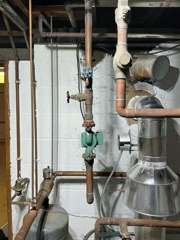 Inspected boiler system and identified leaking heat exchanger on boiler #2. Visual assessment confirmed signs of corrosion on copper piping and compromised connections. Recommended complete replacement of aging unit due to component failure and deteriorated condition.